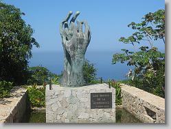 THE HANDS:  Are the expression of brotherhood, through two right hands pointing to the skies imploring peace. 
THE WATER:   Symbol of purity falling from the baptismal basin at the entrance of the Chapel, then cascading down to the lower level and flowing out toward the sculpture of the hands, thus uniting the Chapel, the public crypts and the beautiful outdoors. 