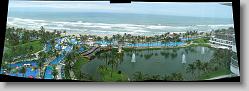 Panoramic photo (3 pictures) of water park, lake, pool and ocean from top of hotel at Mayan Palace.